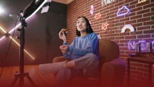 Youtuber com fones de ouvido analisando gráficos financeiros ao lado de contador em escritório moderno